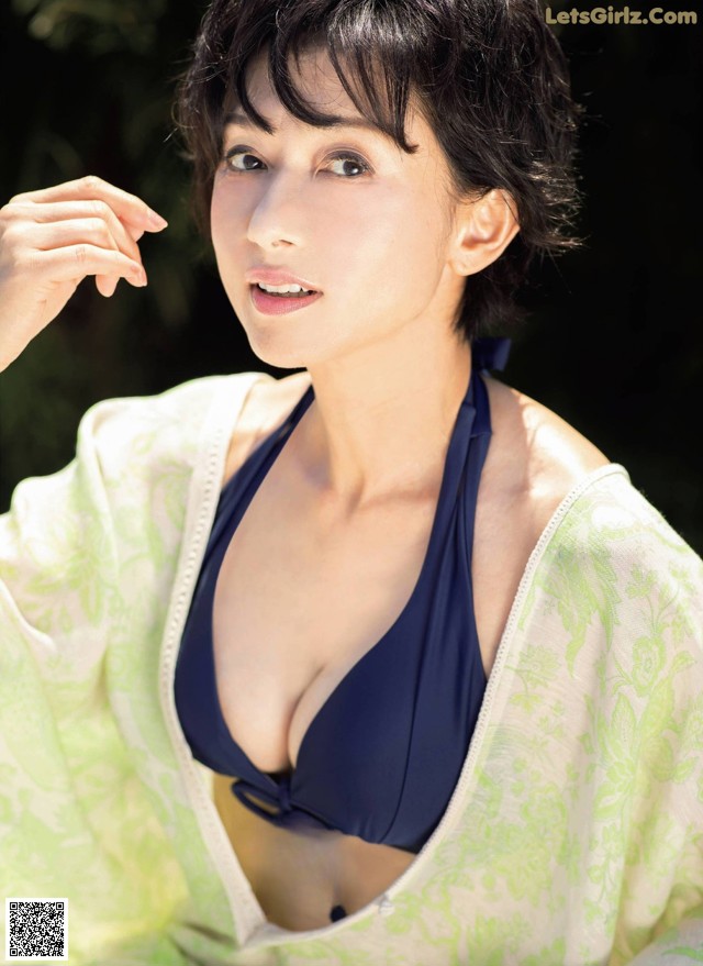 A woman in a blue bikini top posing for a picture.