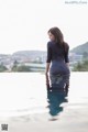 A woman sitting on the edge of a swimming pool.