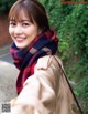 A woman wearing a red and blue plaid scarf smiles at the camera.