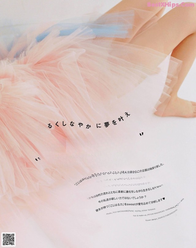 A woman in a pink tutu sitting on a white surface.