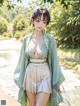 A woman in a green kimono standing in front of a pond.