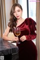 a woman in a red dress holding a glass of wine