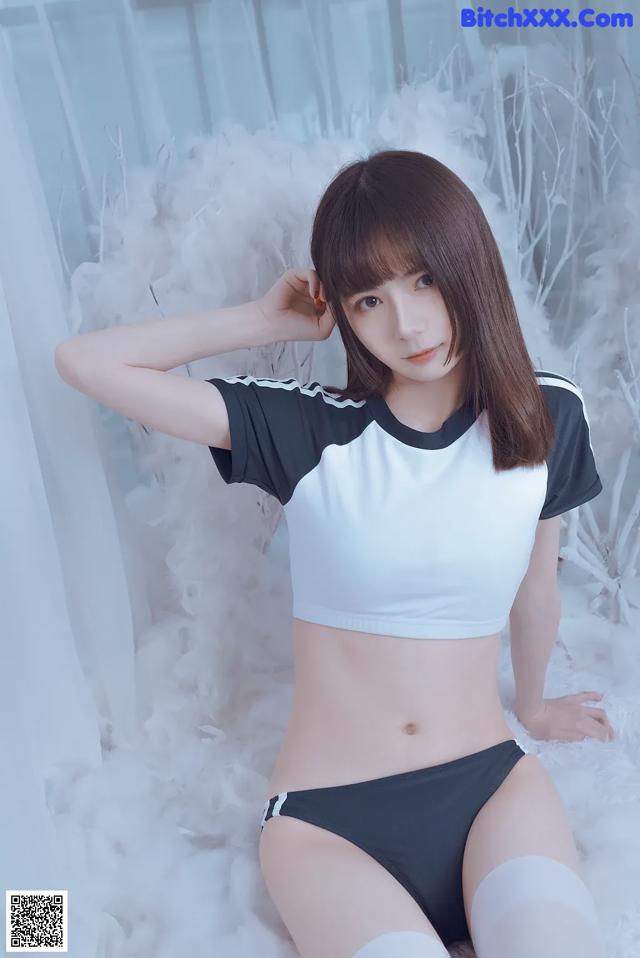 A woman in a white and black top and black panties.