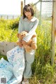 A woman sitting on a bench holding a teddy bear.