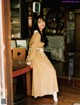 A woman in a long dress sitting at a table.