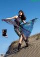 A woman in a dress is standing on a sand dune.