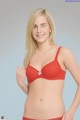 A woman in a red bra and panties posing for a picture.