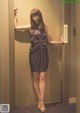 A woman in a purple dress standing in an elevator.